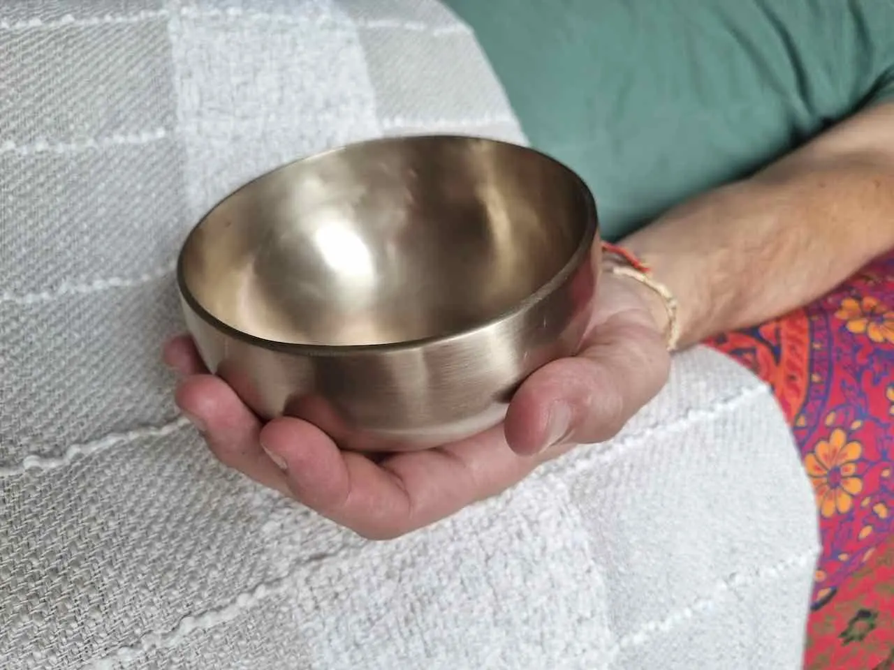 bol tibetain pose dans une main durant un massage sonore