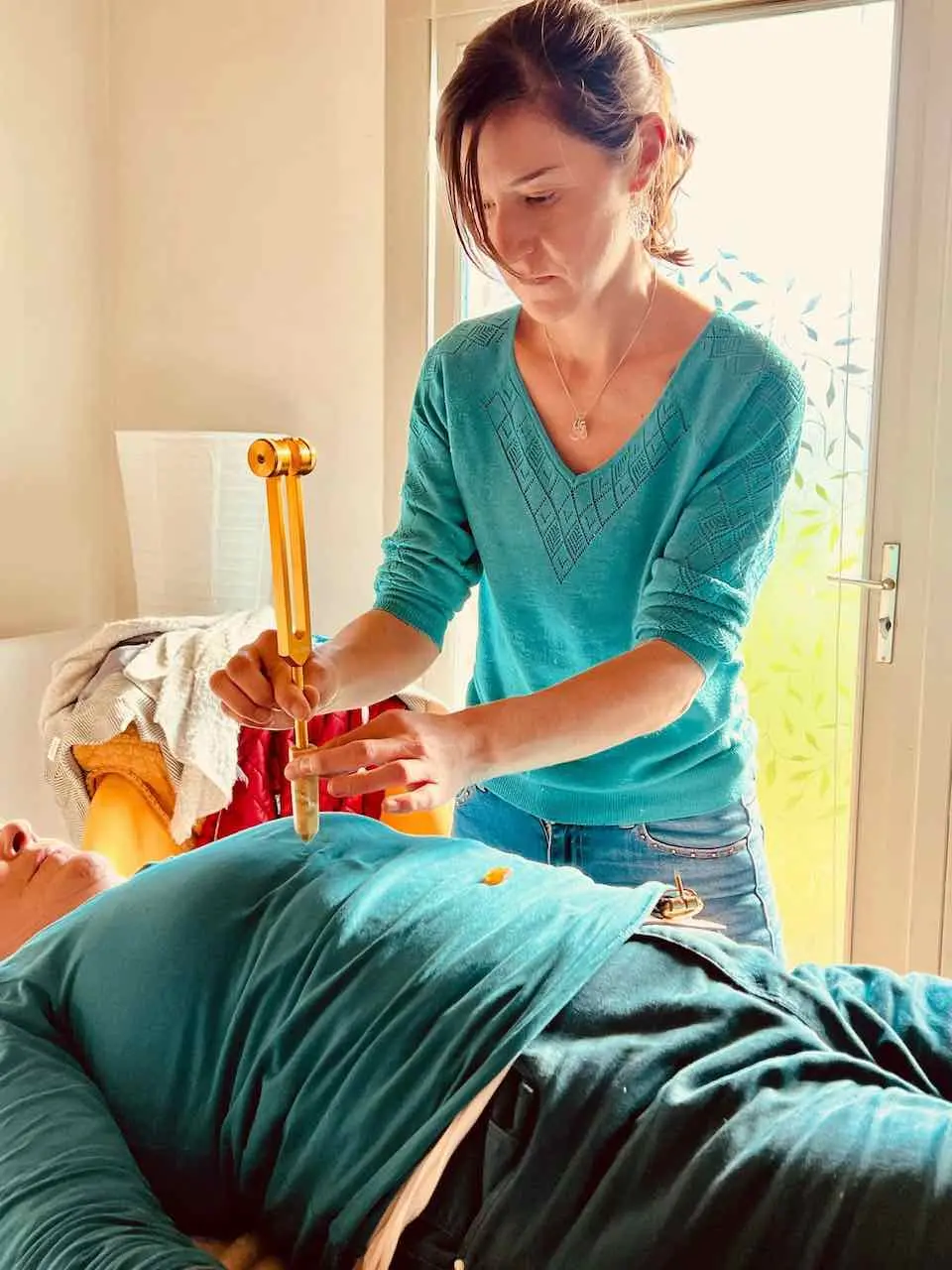 sonotherapeute donnant un massage aux diapasons