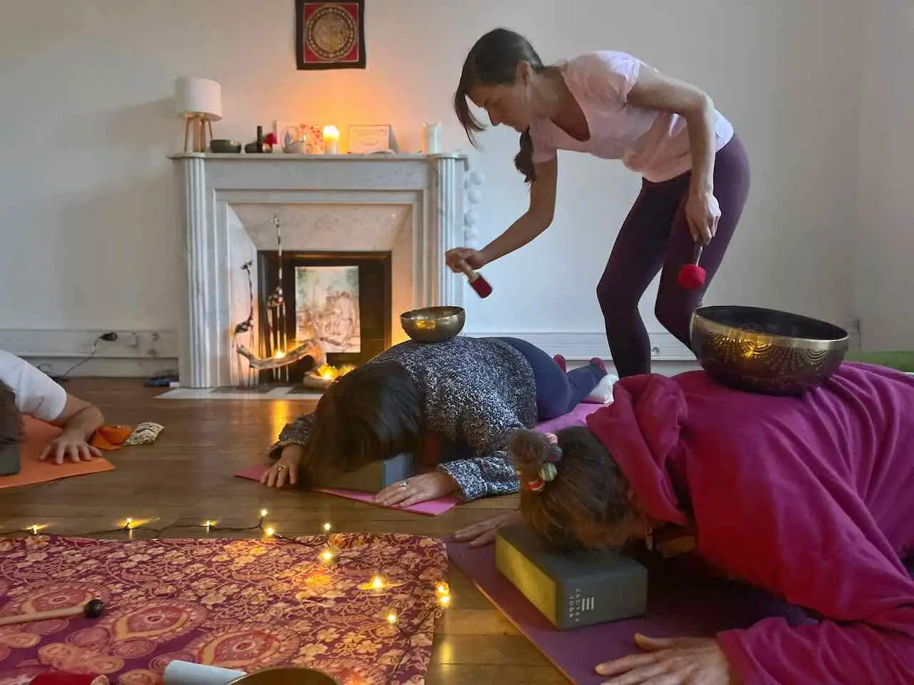 sonotherapeute frappant un bol pose sur une personne