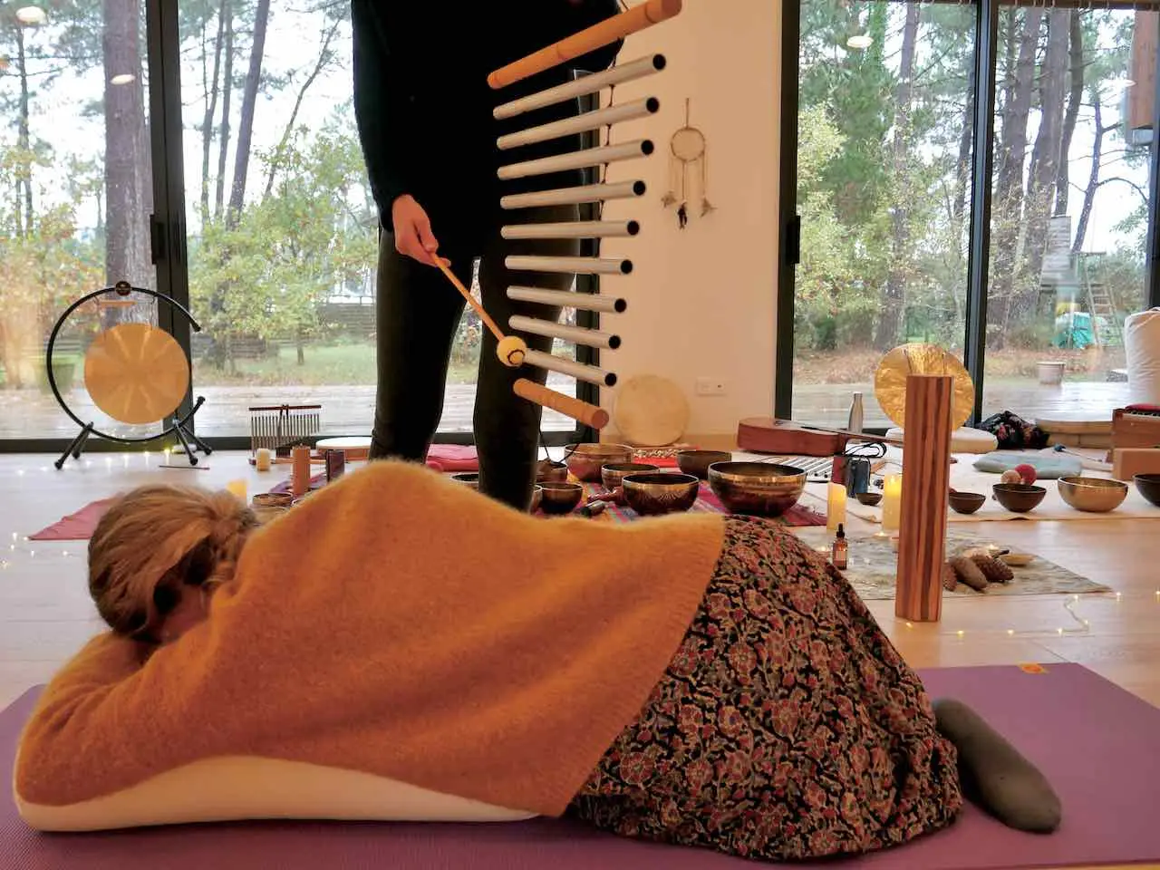 sonotherapeute jouant du tubalophone au dessus d un personne